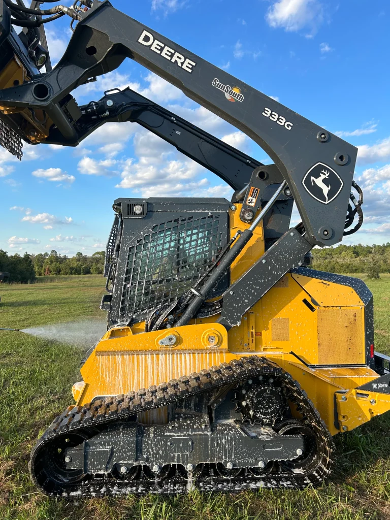 Deep South Mulching skid steer equipment being maintained after land clearing job